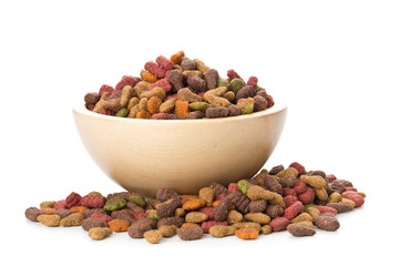 Heap of dry pet food in wooden bowl