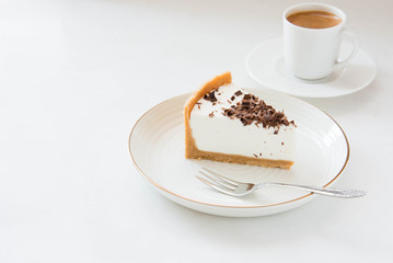 Homemade Cheesecake with chocolate and a cup of coffee on a white background.