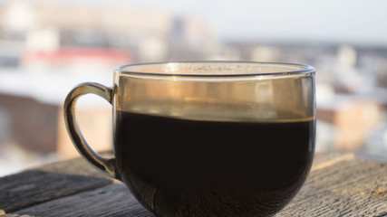 Cup of coffee on a wooden table on a winter background