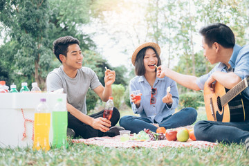 Young teen groups having fun picnic in park together.
