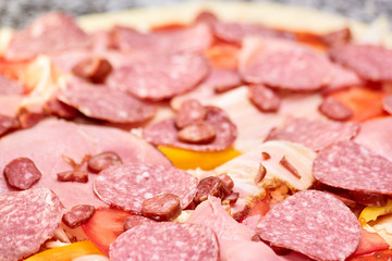 Pile of salamis, hams and hunting sausages closeup. Close up large pile of sliced cold meats.