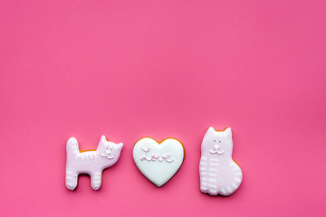 Valentine cookies. Hearts with lettering I love you, cat and puppy on pink background top view space for text