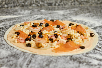 Close up unbaked seafood pizza with ingredients. Uncooked pizza ingredients, close up.