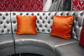 gray leather sofa with red pillows