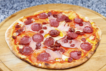 Thin Crust Genoa Salami Pizza. Spicy salami pizza on wooden board, top view.