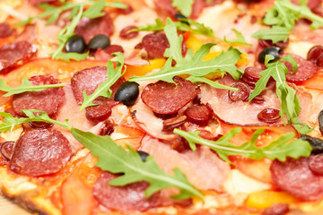 Salami pizza ingredients backround. Close up salami, sausages, ham and arugula.