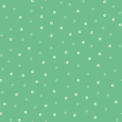 Seamless pattern with little cartoon white flowers on green background.