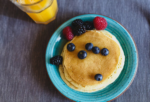 Pancakes with fresh wild berries and maple syrup