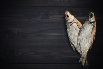 Dried fish breams on dark wooden table with copy space. Beer snack in Russia.