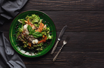 Caesar salad with quail eggs and chicken meat