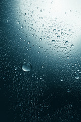 Bubbles of water on a shaded surface, blue background