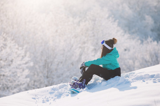 Woman Snowboarder Sitting On High Hill And Rest