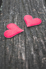 Top view of two red hearts on an old, rustic wooden background. Vintage toned. Love or Happy Valentine's Day background