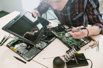 Fototapeta na wymiar Computer engineer fixing disassembled laptop. Science technology electronics design development