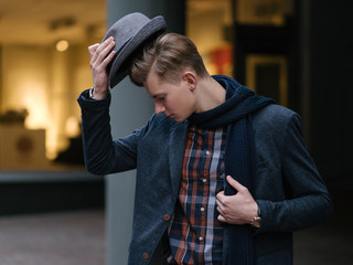 Stylish young man taking off his hat. Fashionist and trend setter. Love for clothing. Haute couture...
