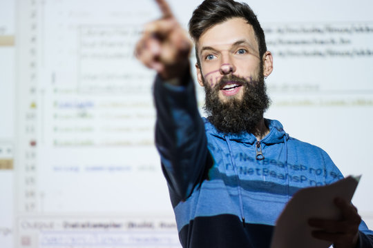 Elocution or speech craft courses. Bearded young male orator interacts with someone in the audience pointing a finger. Dialogue, discussion and rhetoric basics concept