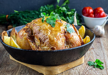 Whole roasted chicken with potato on a pan