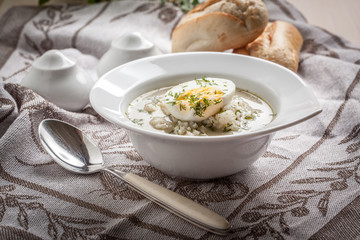 Sorrel soup with egg in white bowl.