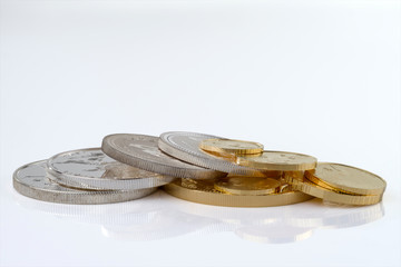 Gold and silver coins in close up isolated on white background.