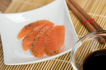 Sashimi aus geräucherten und gebeizten Lachs mit Holzstäbchen und Sojasauce