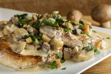 Pork sirloin with white sauce made from sour cream and mushrooms with parsley