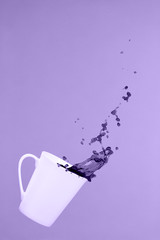 Levitating coffee mug with splashes. Coffee concept. Minimal art trend. Solid pink background
