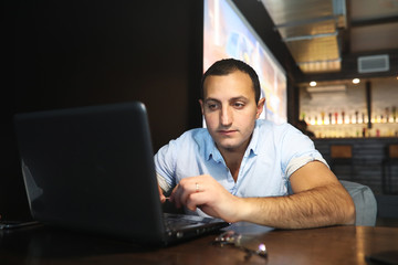 Armenian handsome man working behind laptop