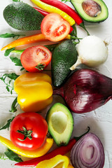 Set of fresh vegetables on a light background: tomatoes, peppers, chili, avocado, greens, onion. The concept of natural healthy eating, vegetarianism, vitamins.