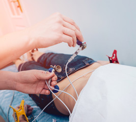 Doctor with electrocardiogram equipment making cardiogram test