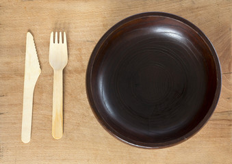 Wooden plate knife and fork on wooden background