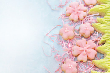 Homemade pink cherry blossom cookies, Easter holiday theme sweeties decoration background, toned