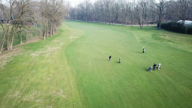 aerial view of a golfer hits a ball with the bat in a golf course with other players