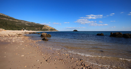 Beach with turquoise sea water with amazing rocks. Setubal in Portugal