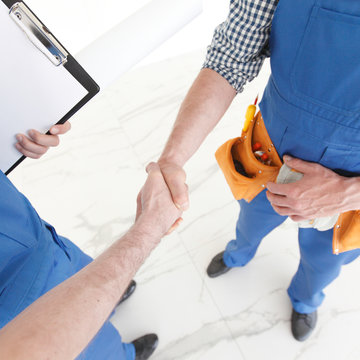 Two construction workers shaking hands