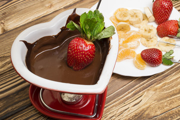 Chocolate fondue with strawberries and fruits served in a restaurant. Valentine's Day