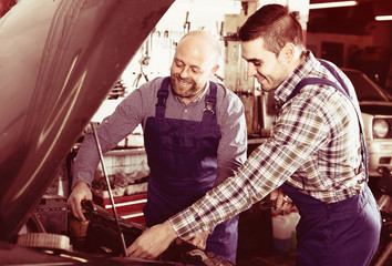 Two car mechanics at workshop