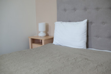 Interior of cozy light gray bedroom in minimalist design