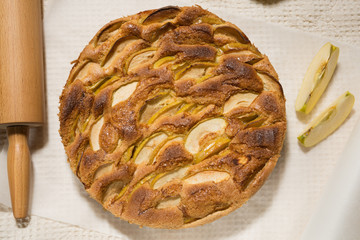 freshly baked apple pie, on a table on parchment paper, golden crust