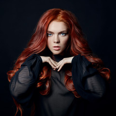 Beautiful woman with red hair on a black background. Portrait of a successful woman, pure skin,...