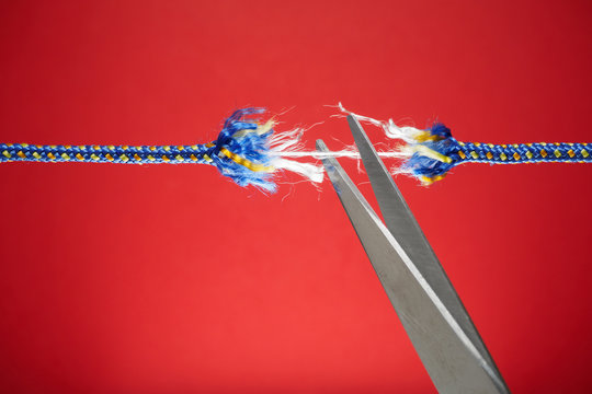 Cutting frayed rope with scissor - tension, stress and risk concept