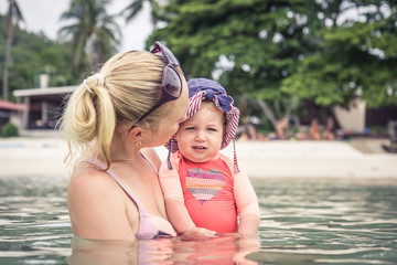 Fototapeta na wymiar Mother and child enjoy swimming in sea during travel beach holidays 