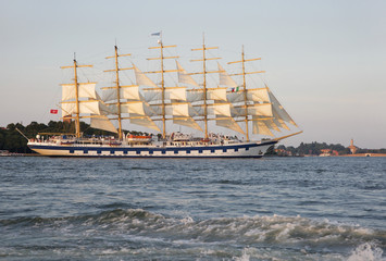 A full-rigged ship with traditional mast and sails moving in Venice water