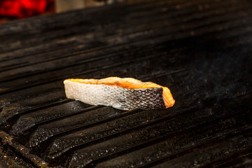 A slice of salmon fried on a grill