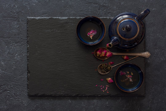 Black stone background with cups of herbal tea