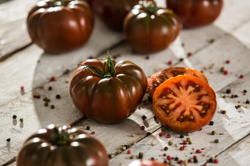 tomate negro raf, medio tomate. fondo de madera