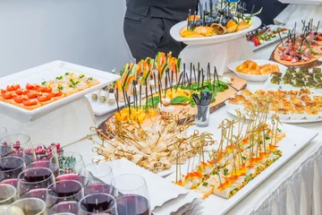  Catering table with food dishes, snacks and alcoholic and non-alcoholic drinks for guests of the event. Service at business meeting, party, weddings. Selective focus. © okrasiuk