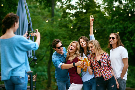 Group Of Friends Taking Photos Outdoors.