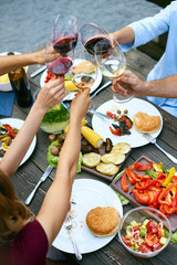 People Cheering With Drinks At Outdoor Dinner Party