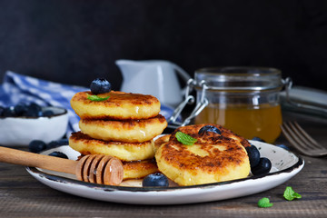 Classic Russian breakfast - cheesecake with honey and berries.