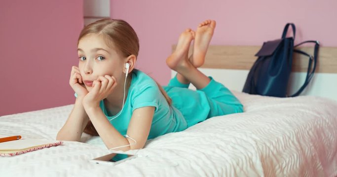 Girl 9 years using cell phone when lying on the bed and laughing